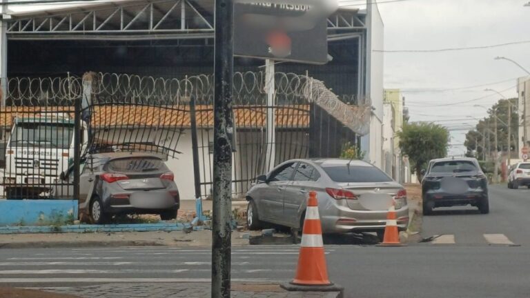 Carro avança sinal vermelho e colide com outro veículo em Uberlândia, invadindo estacionamento de concessionária