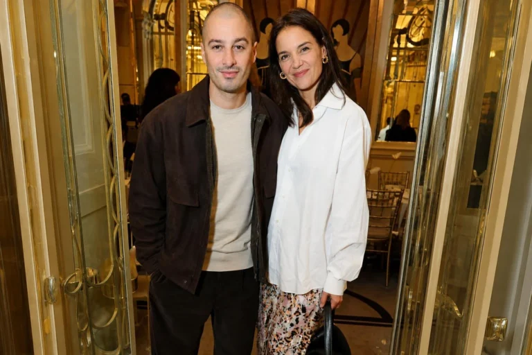 Katie Holmes combina jeans bicolor e jaqueta xadrez em viagem ao lado do namorado